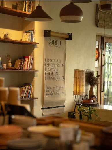 Inside Cafe AMADO: wooden shelves, books and pendant lamps